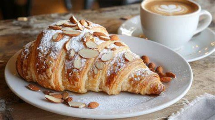 a croissant and latte sitting on a table top