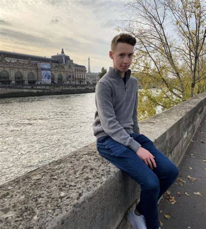 an english teacher in paris smiling and standing in front of the eiffel tower