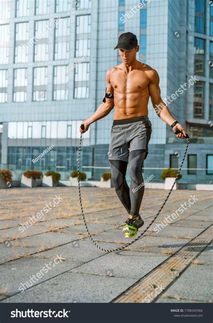 Athletic man skipping rope at gym