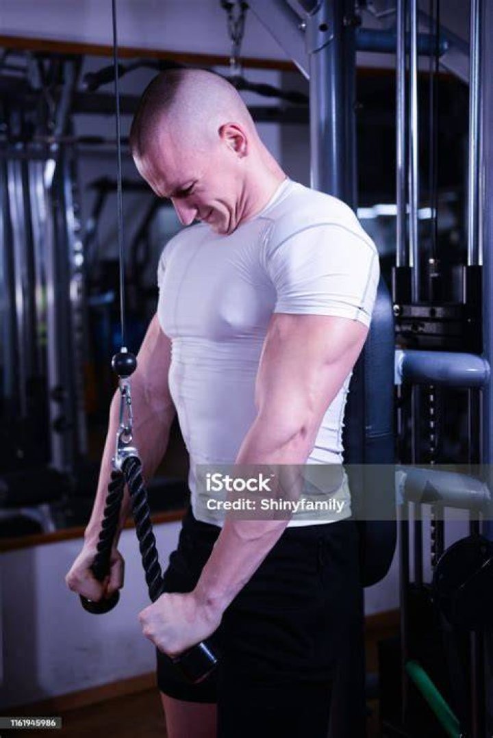 Bodybuilder Working On Triceps Extension In Gym bodybuilder working on triceps extension in gym