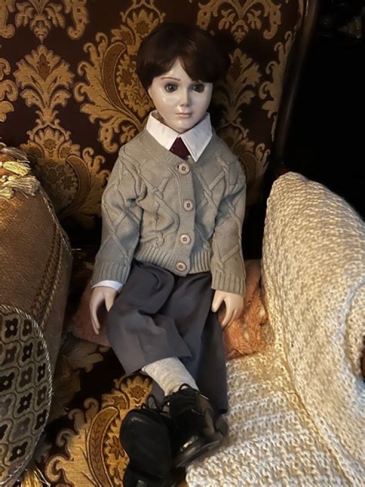 Brahms the doll sitting at a table in The Boy