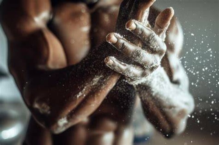 Close up of unrecognizable athlete preparing his hands with powder. Close up of unrecognizable athlete preparing his hands with powder.