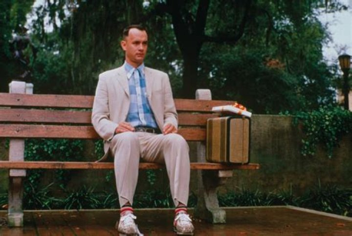 Forrest Gump's feet resting on the ground in his Nike shoes on the deck of his house