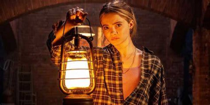 Freya Allan holding a lantern in Baghead