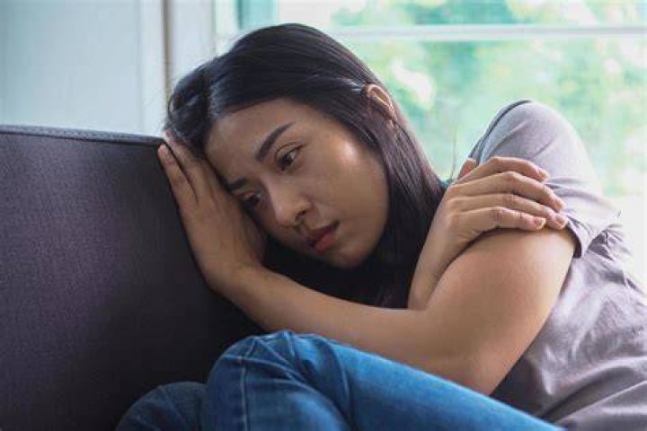 girl worrying while sitting with book