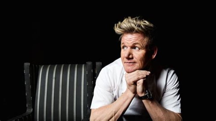 Gordon Ramsay sitting at a table with diners in a scene from an episode of Kitchen Nightmares