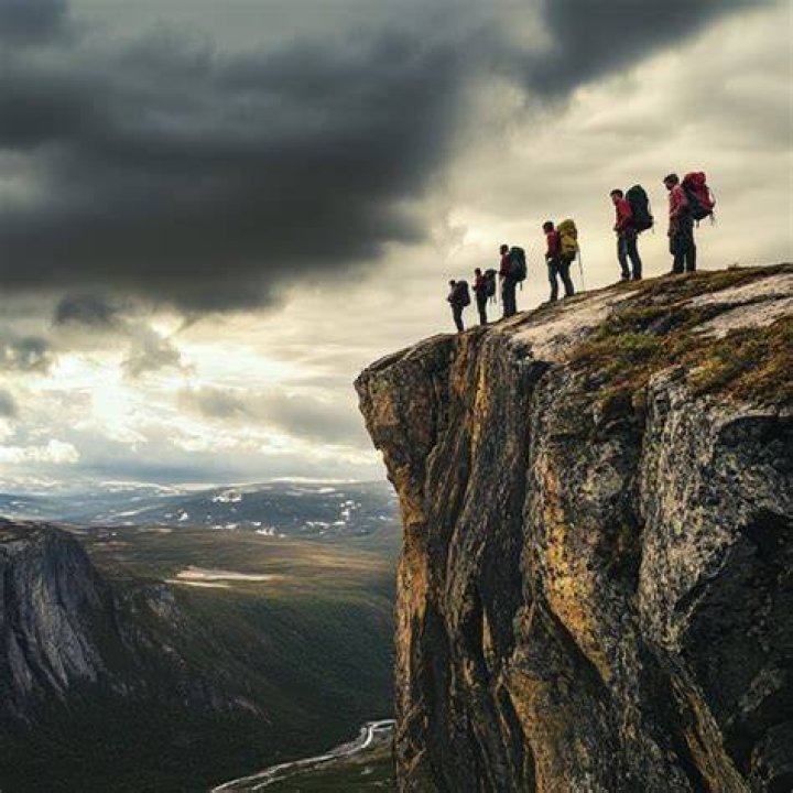 group of hikers on cliff side taking photos