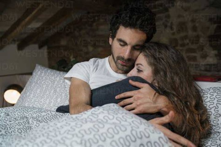 Hispanic couple hugging on bed hispanic couple hugging on bed