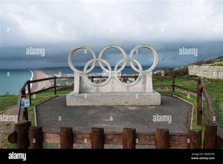 olympic rings monument overlooking beach at sunset