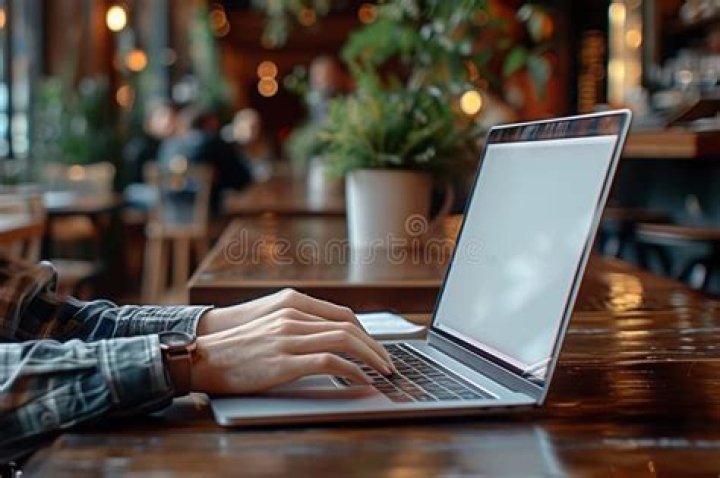 person sitting at table using laptop