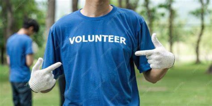 person wearing a colorful volunteer shirt and cap