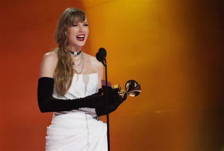 Taylor Swift smiling and holding Grammy