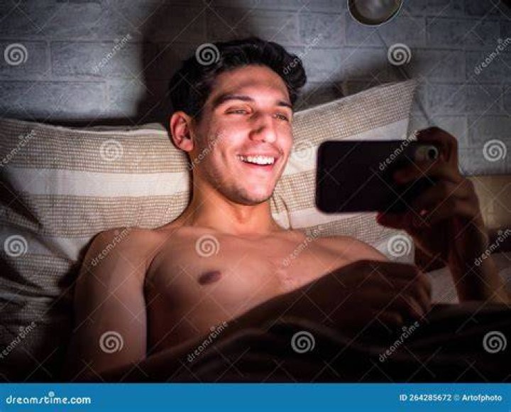 Young man in bed watching pornography on laptop young man in bed watching pornography on laptop